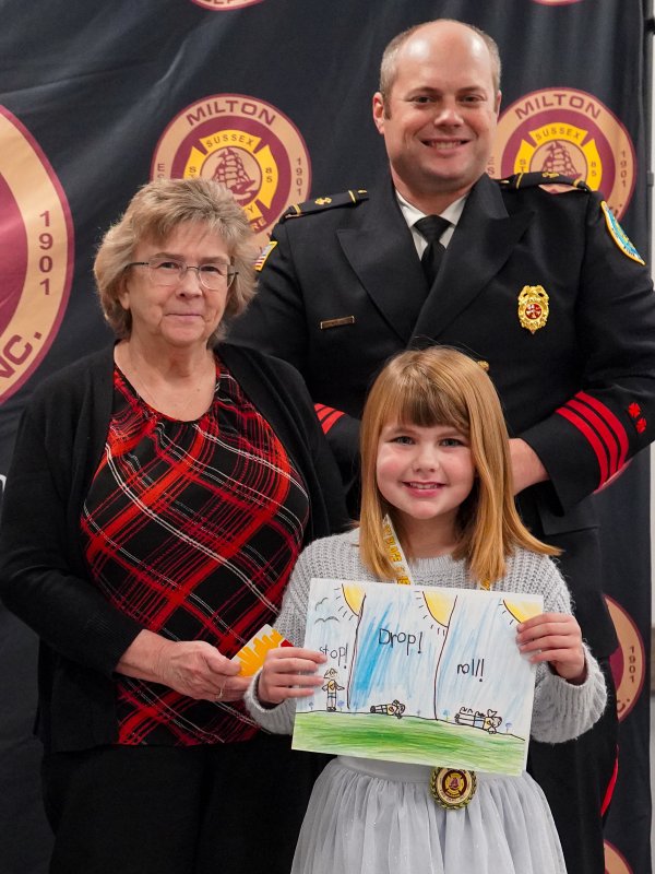 First-grader Charlotte Evans of H.O. Brittingham Elementary School wins the first-place prize, presented by Mary Ann Argo and Bryan Reynolds.